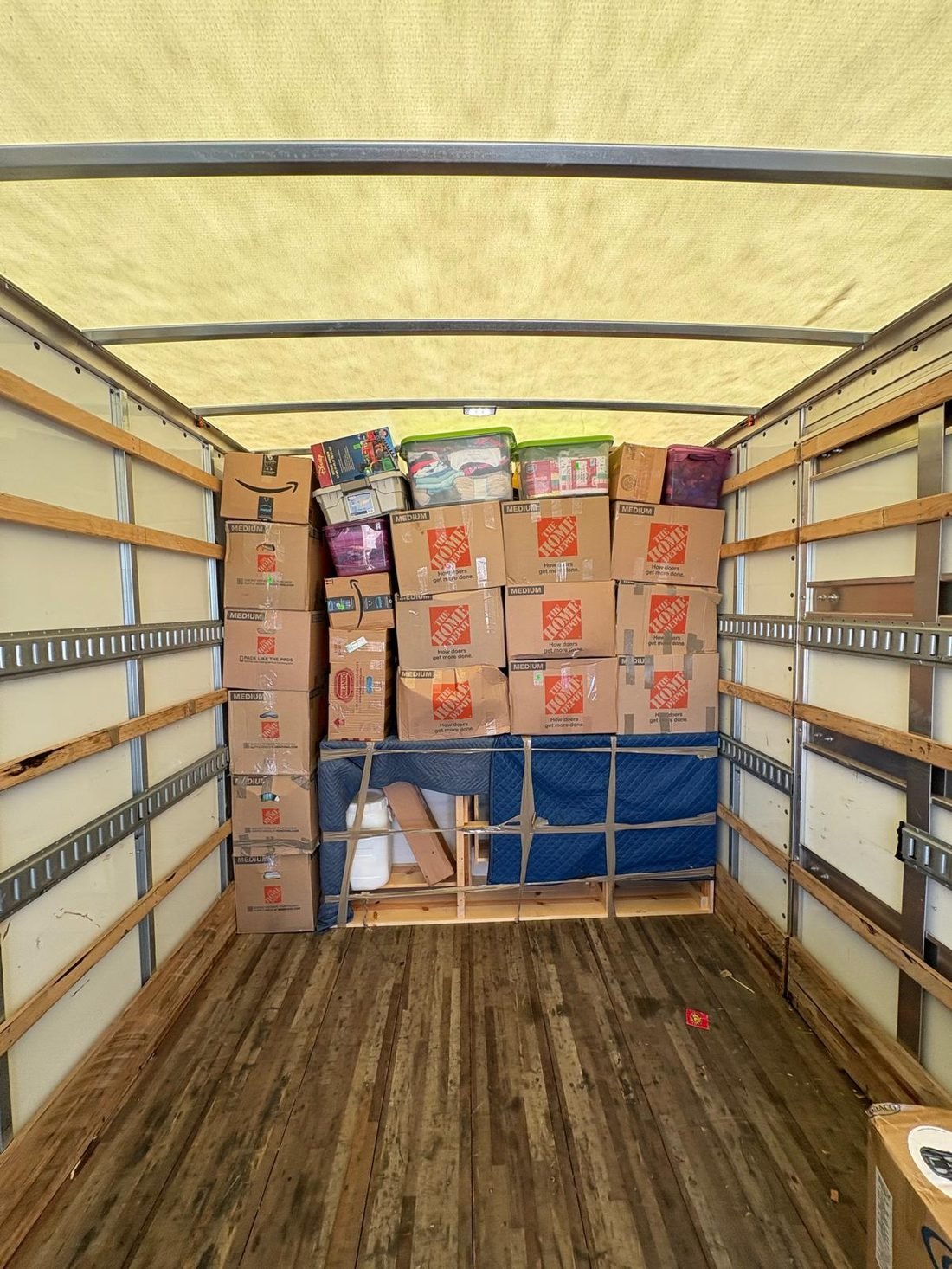 Neatly organized boxes and bins inside the moving truck